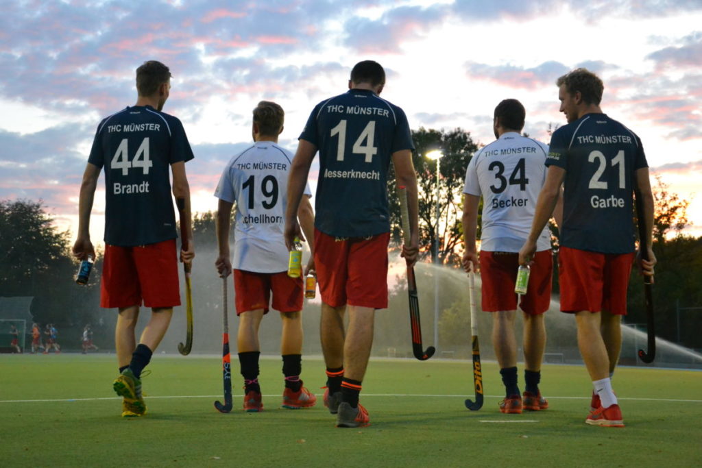 Spieler vom THC Münster gehen dem Sonnenuntergang mit einer liba in der Hand entgegen